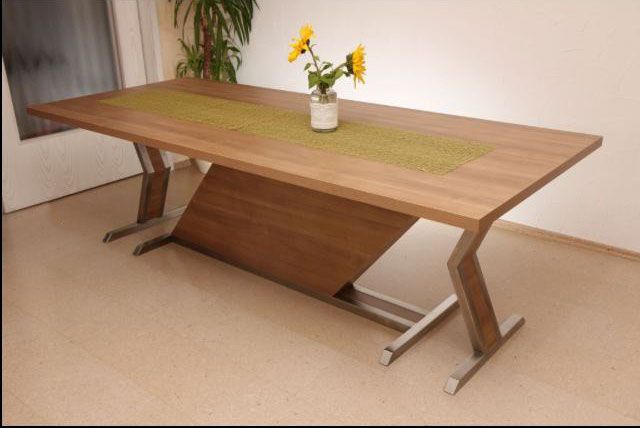 ein Holztisch mit einer Vase mit Blumen darauf