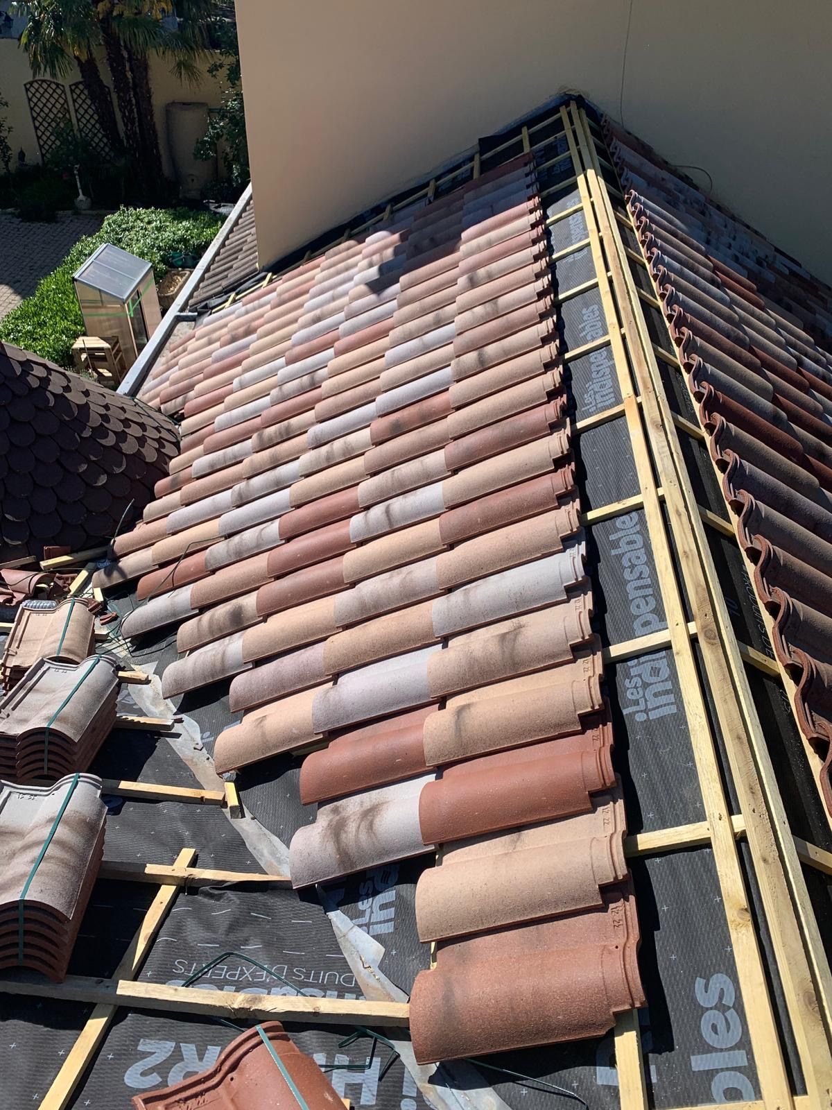 Tuiles entrain d'être posées sur une charpente