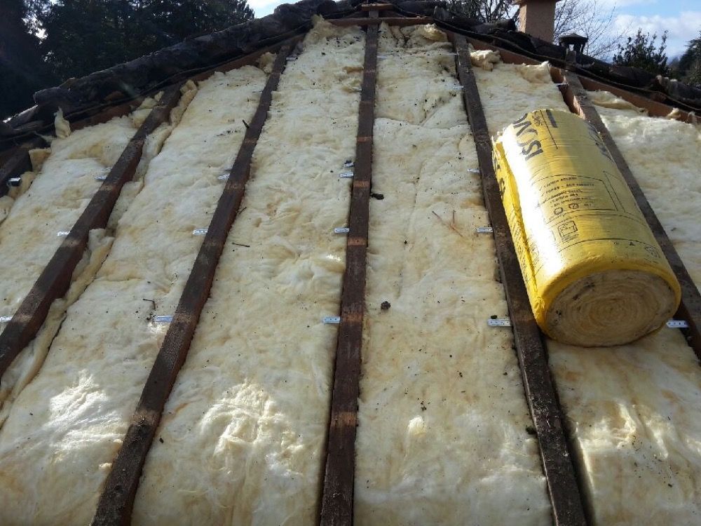 Rouleau de laine de verre sur une toiture en travaux