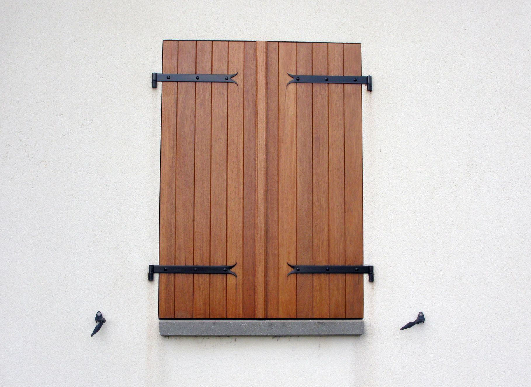 Des volets en bois fermés.