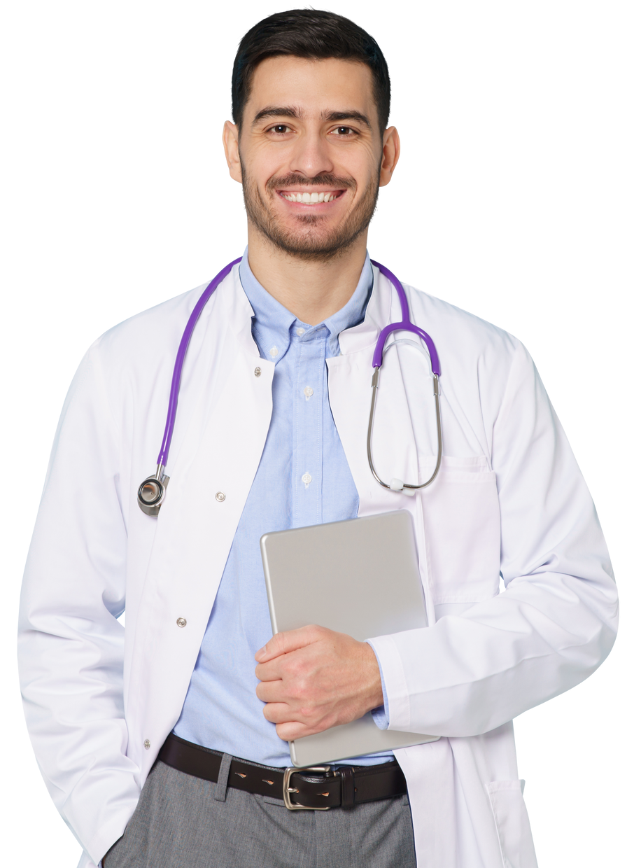 Un médecin souriant en blouse blanche, stéthoscope à la main, tablette enfilée, chemise bleue et pantalon gris.