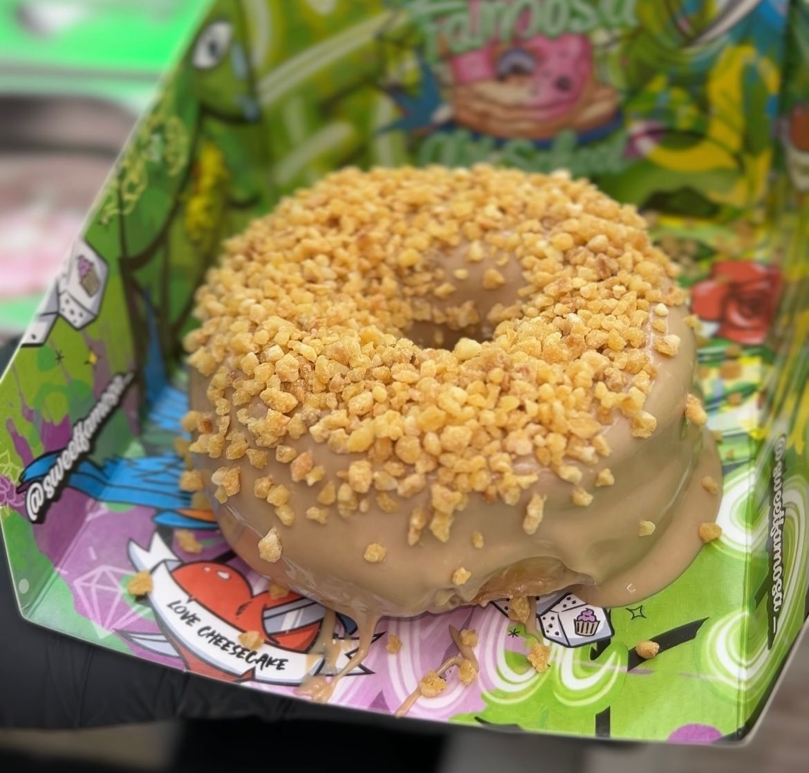 Hay una dona con nueces dentro de una caja.