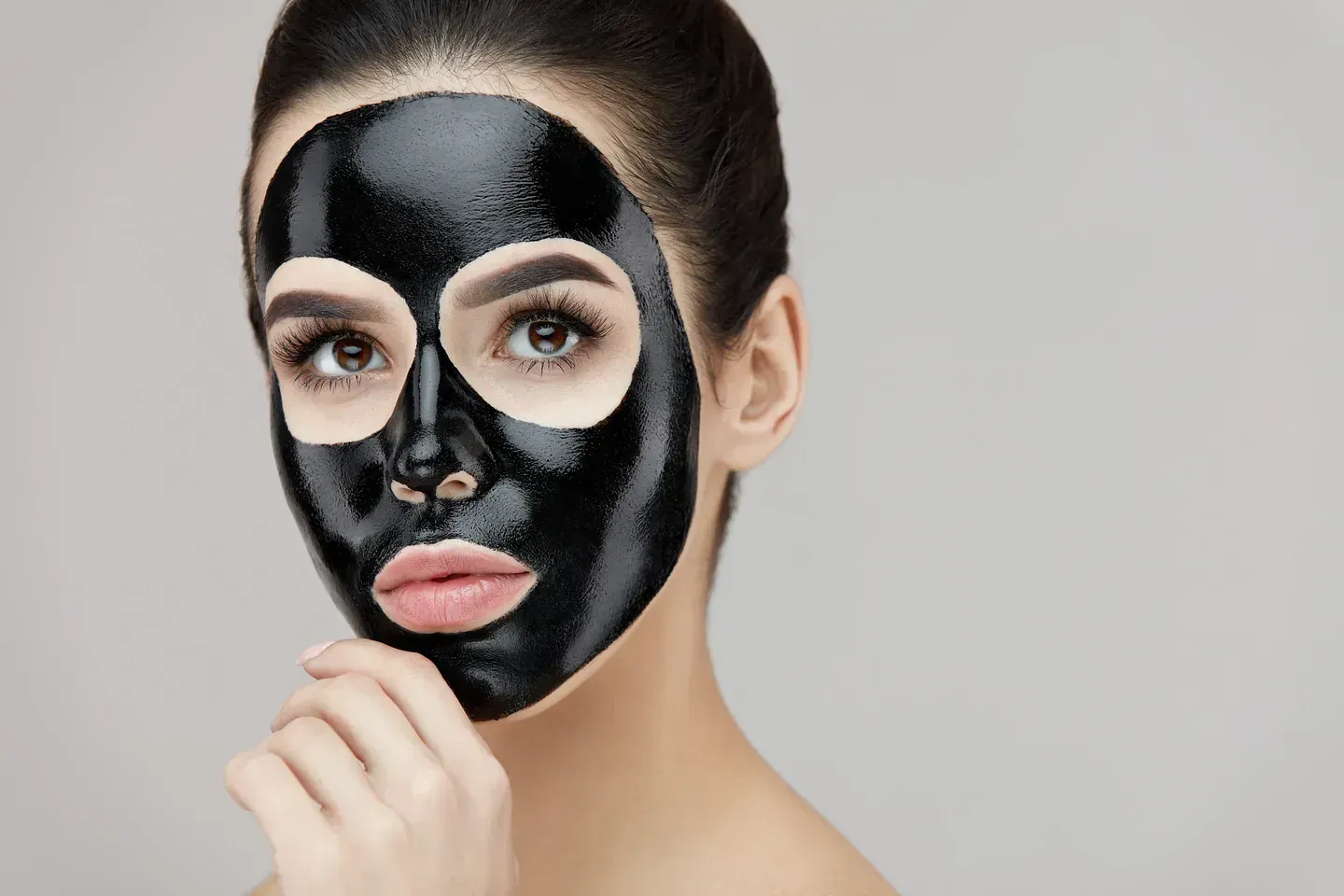 Una mujer lleva una máscara negra en su cara.