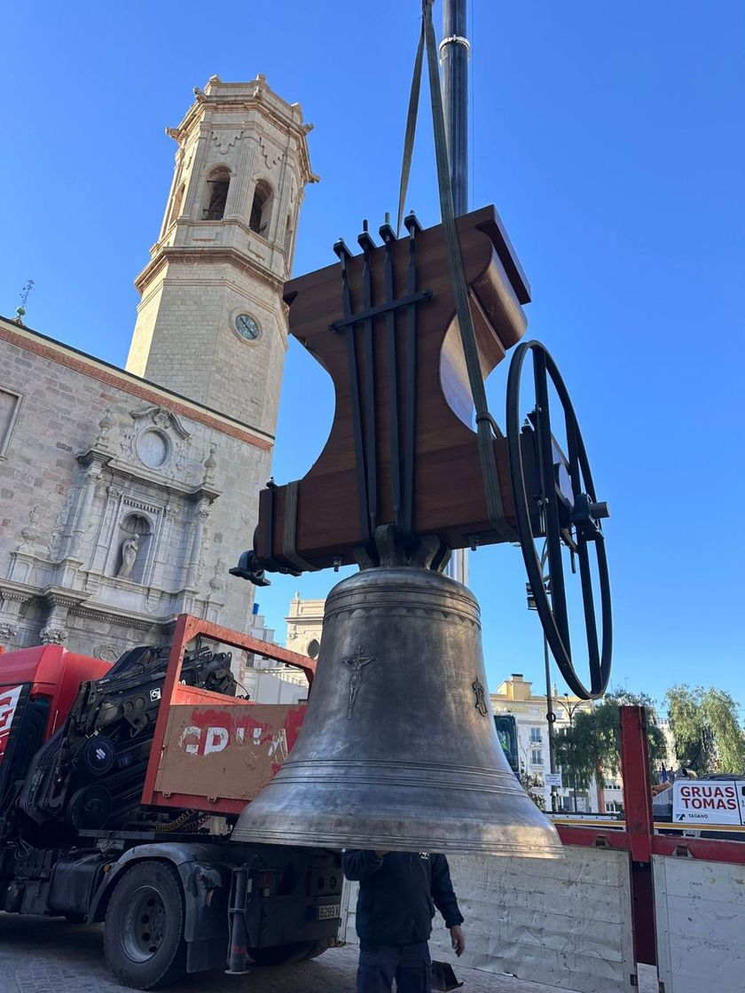 Reloj mecánico antiguo y ornamentado con engranajes a la vista sobre una mesa de exposición en un taller.