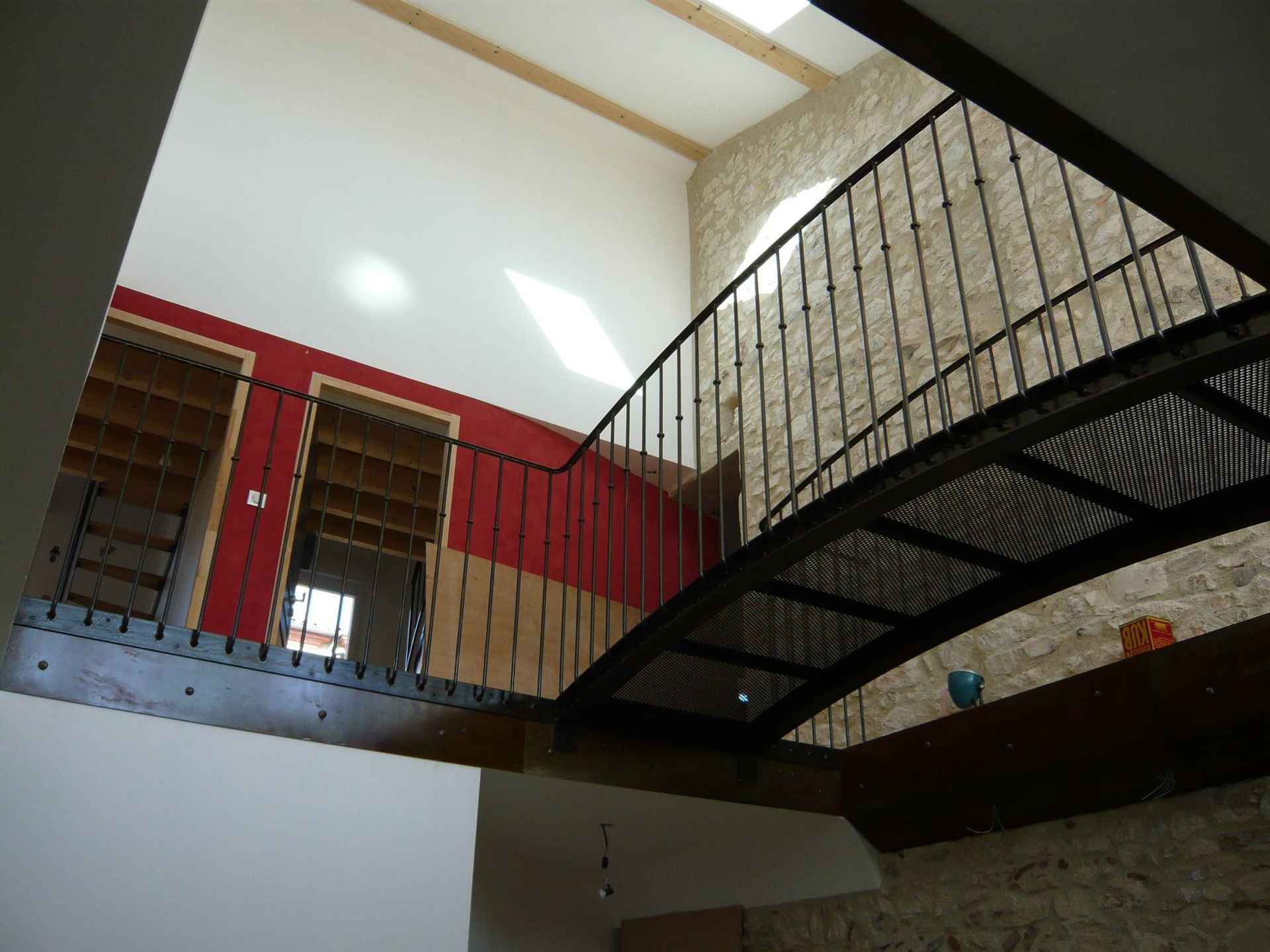 Vue intérieure d'un bâtiment avec une rambarde de pont métallique.