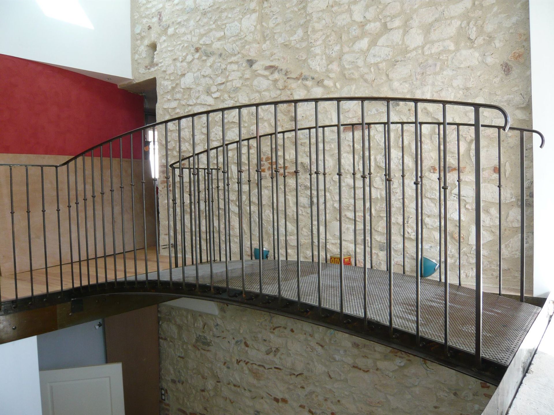 Rambarde incurvée en métal noir sur une plateforme en bois.