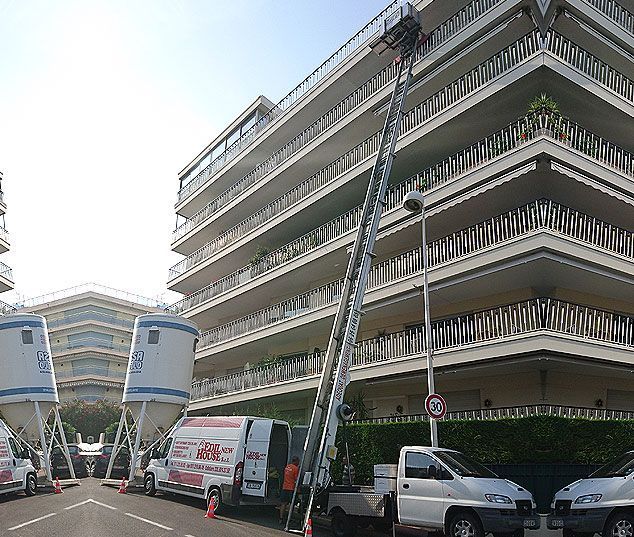 Immeuble d'appartements avec une échelle de camion de pompiers déployée jusqu'aux balcons supérieurs dans une rue de la ville