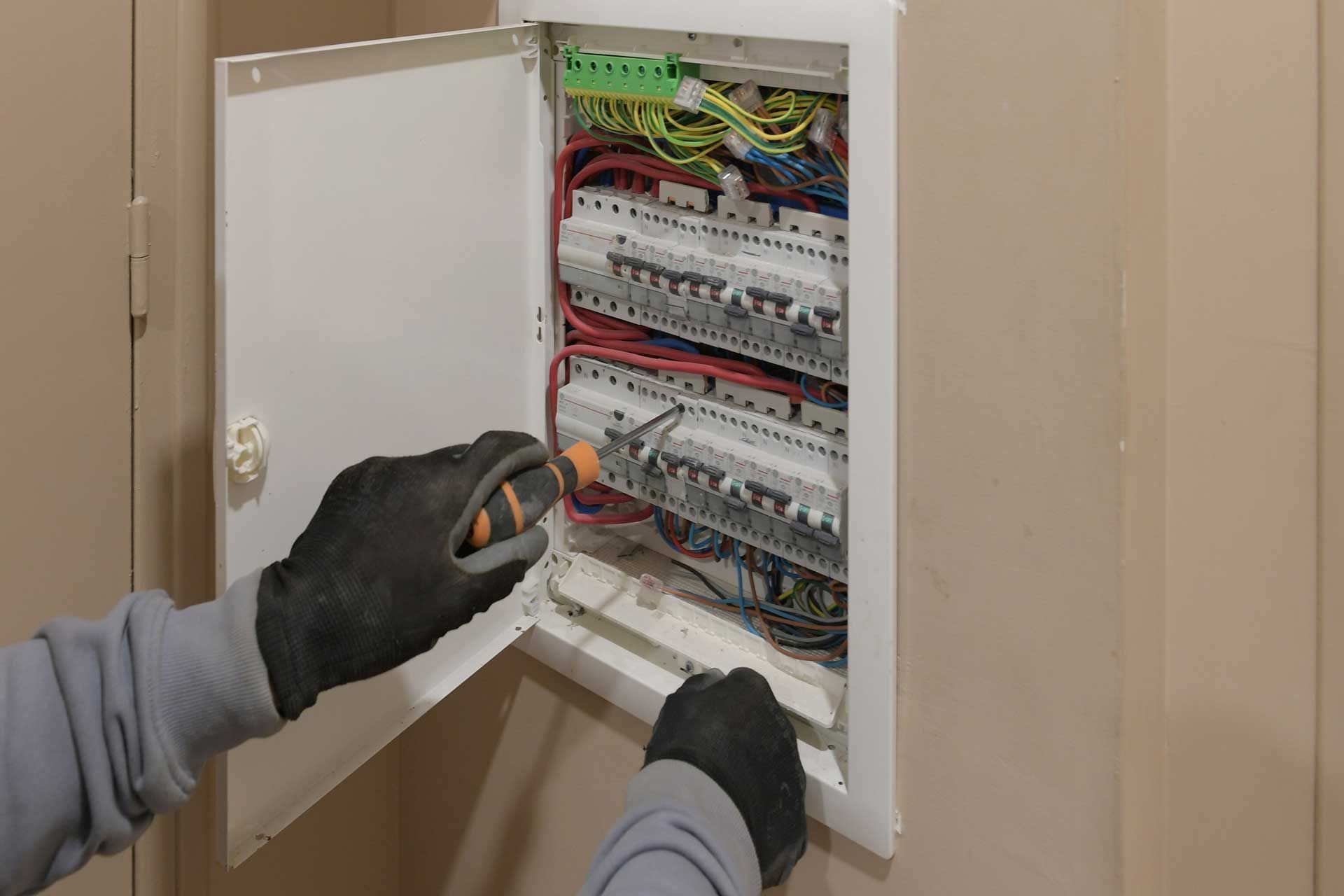 Un électricien intervenant dans une armoire électrique
