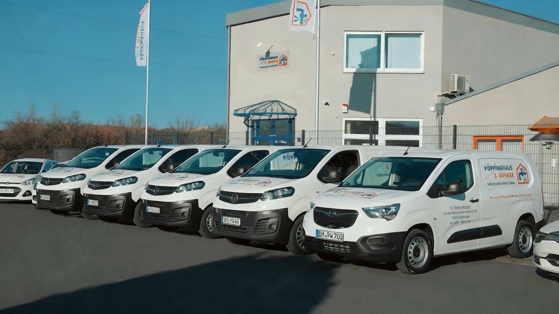 Ein Mann mit einer Schürze, auf der ein Haus steht, steht vor einem weißen Lieferwagen