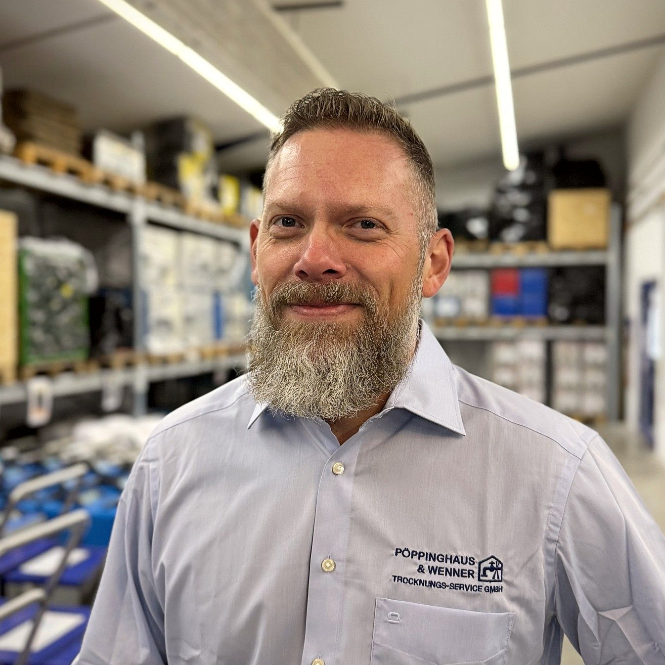 Ein Mann im Anzug und mit Brille lächelt in einem Kreis.