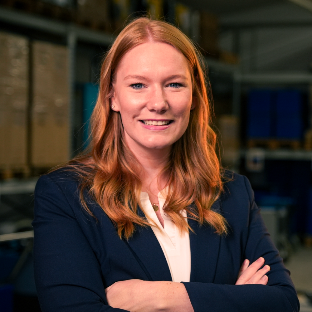 Eine Frau mit langen roten Haaren lächelt in einem Kreis.