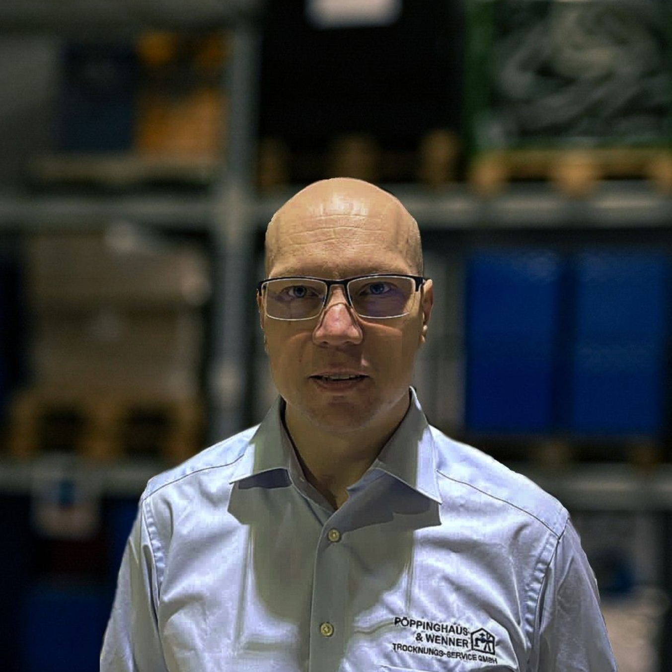 Ein Mann in Anzug und blauem Hemd lächelt in einem Kreis.