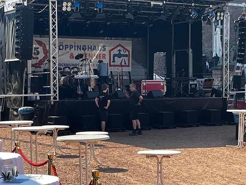 Eine Gruppe von Menschen steht vor einer Bühne.