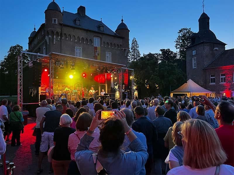 Eine Menschenmenge, die ein Konzert vor einem Schloss ansieht