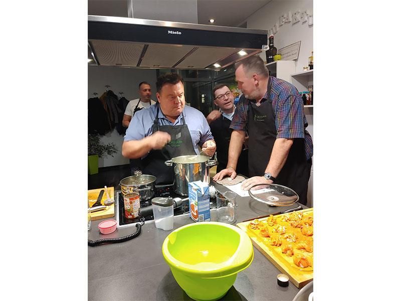 Eine Gruppe Männer bereitet in einer Küche Essen zu.