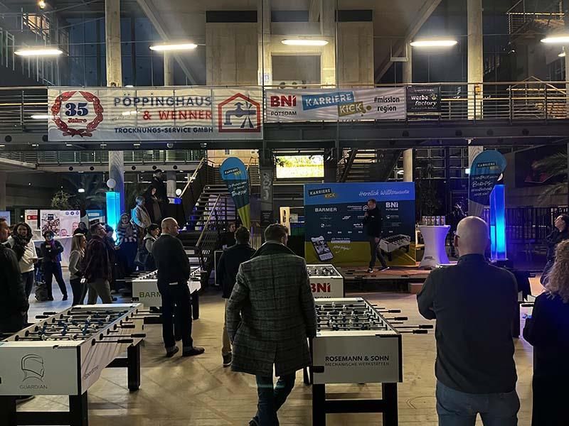 Eine Gruppe von Menschen steht in einem Raum mit einem Schild mit der Aufschrift „Poppinhaus“