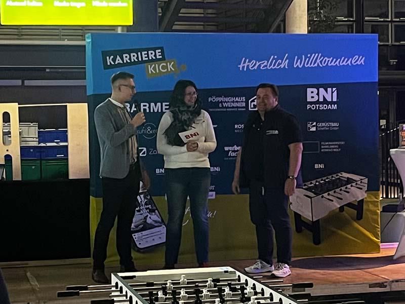 Eine Gruppe von Menschen steht vor einer blauen Wand.