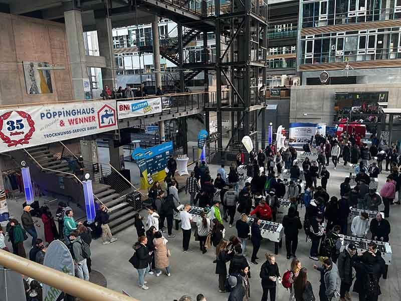 Eine große Gruppe von Menschen hat sich in einem großen Gebäude versammelt.