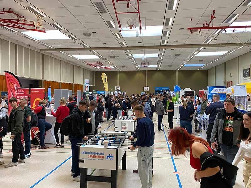 Eine große Gruppe von Menschen hat sich in einem großen Raum versammelt.