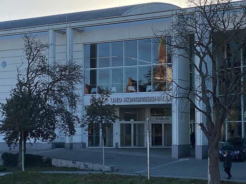 Ein großes weißes Gebäude mit vielen Fenstern und Bäumen davor