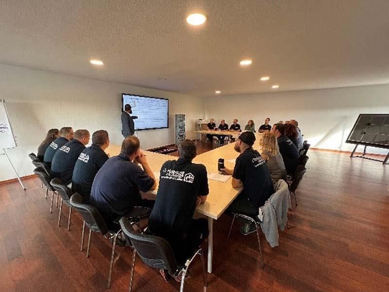 Eine Gruppe von Leuten sitzt in einem Konferenzraum um einen Tisch herum.