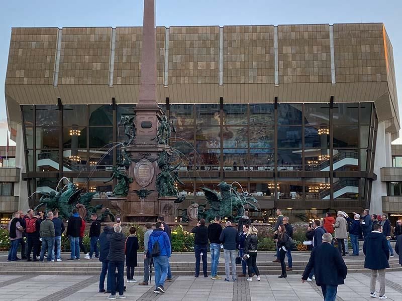 Eine Gruppe von Menschen steht vor einem großen Gebäude