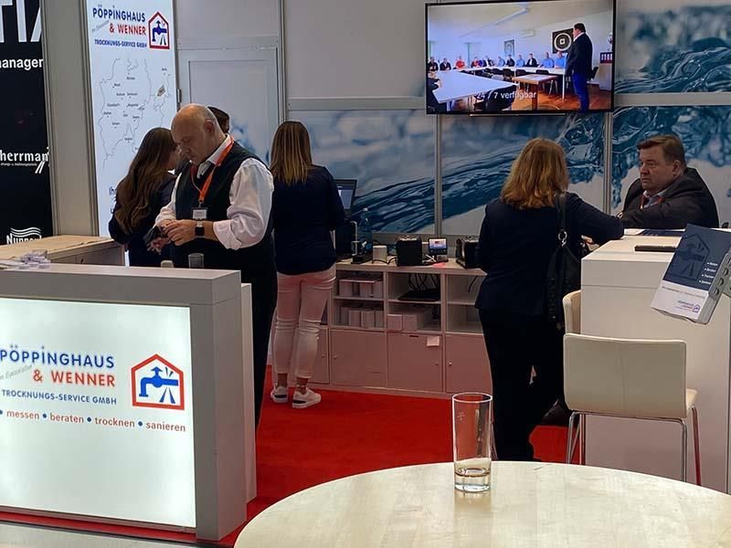 Eine gruppe von menschen steht um einen tresen mit der aufschrift poppinghaus & werner