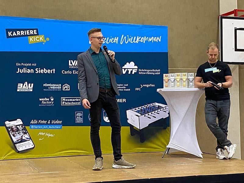 Ein Mann steht auf einer Bühne und spricht in ein Mikrofon