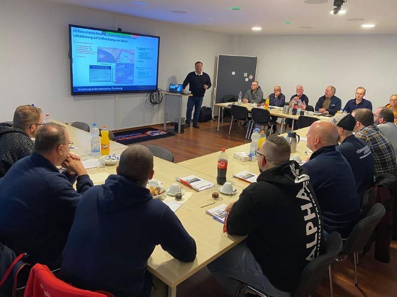 Ein Mann hält eine Präsentation vor einer Gruppe von Männern.