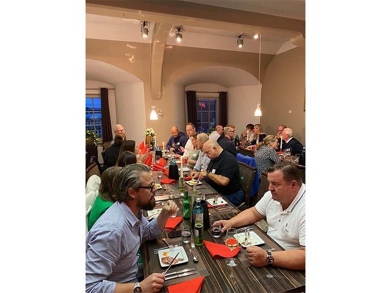 Eine Gruppe Leute sitzt an einem langen Tisch und isst.