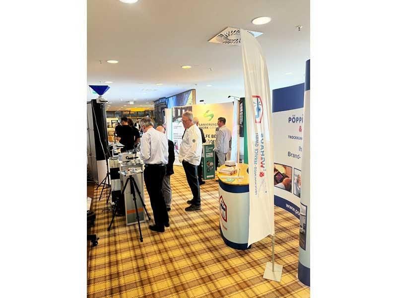 Eine Gruppe von Leuten steht in einem Raum und unterhält sich.