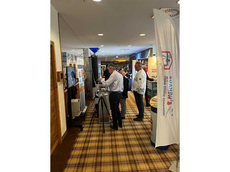 Eine Gruppe von Männern steht in einem Flur und unterhält sich.