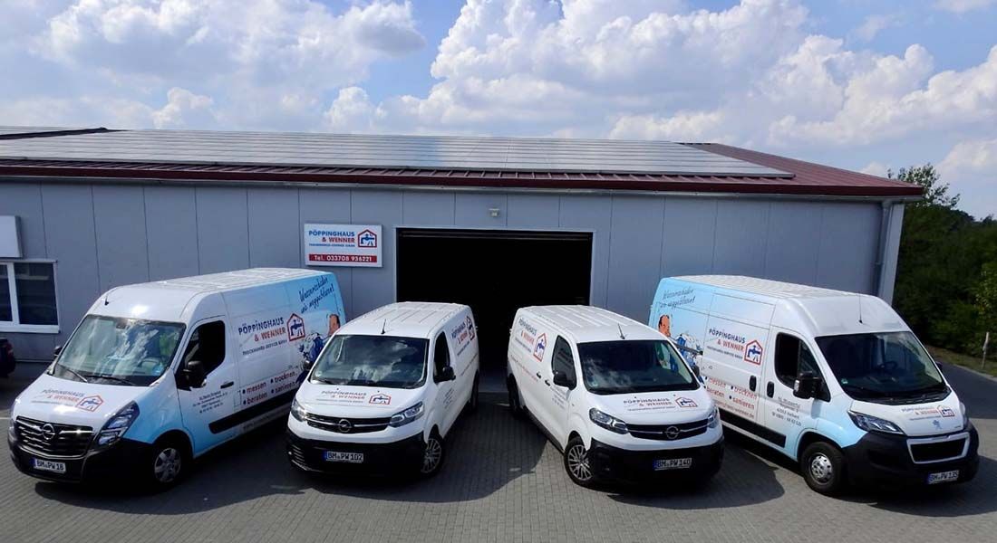 Vier weiße Lieferwagen stehen vor einem Gebäude