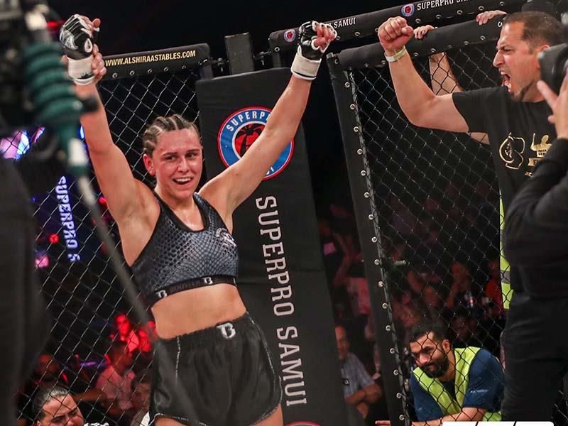 Eine Frau steht vor einem Schild mit der Aufschrift „Superpro Samui“