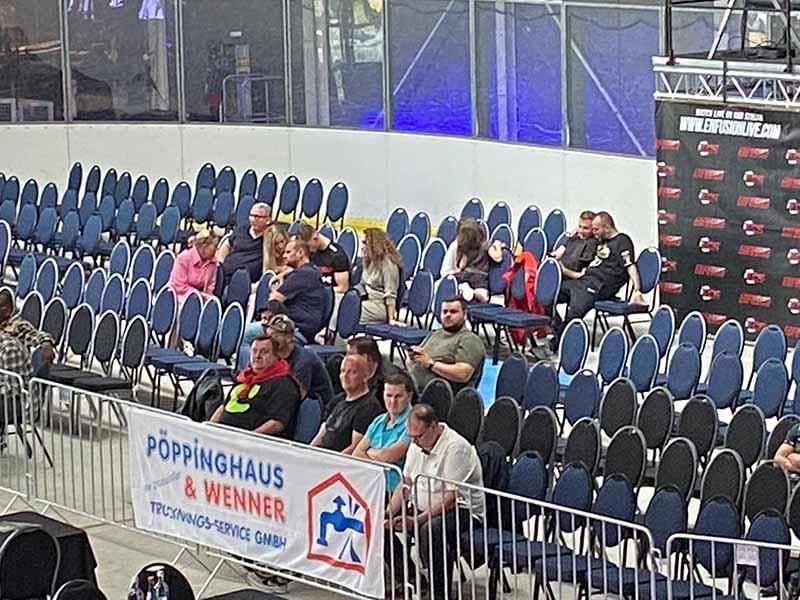 Eine Gruppe von Leuten sitzt in einem Stadion und sieht sich ein Spiel an.