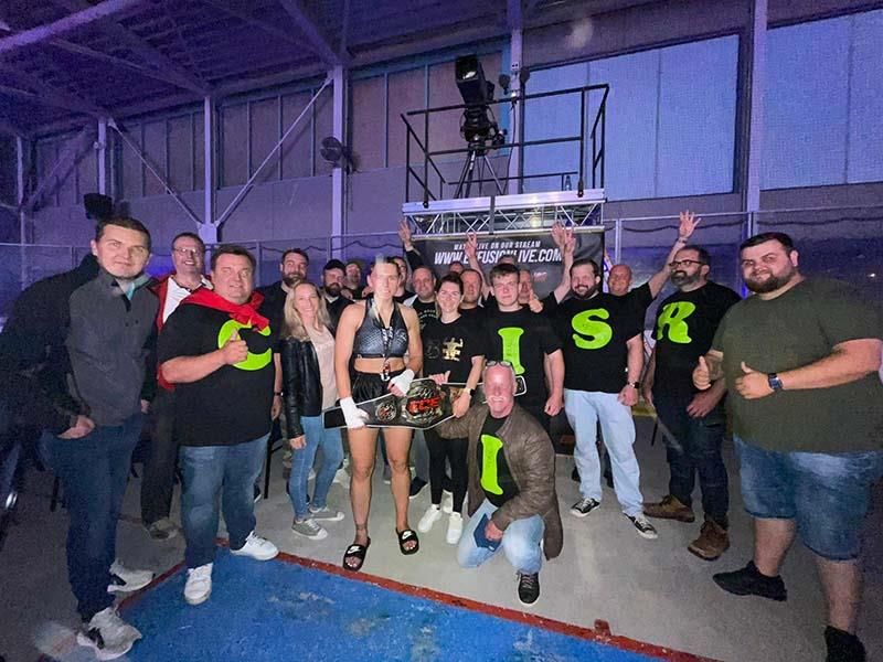 Eine Gruppe von Menschen posiert für ein Foto und einer von ihnen trägt ein T-Shirt mit dem Buchstaben S darauf