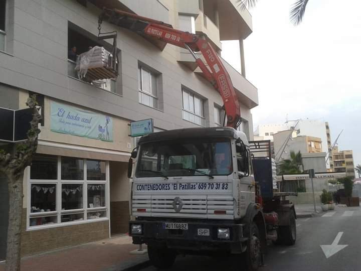 Un camión grúa está estacionado frente a un edificio
