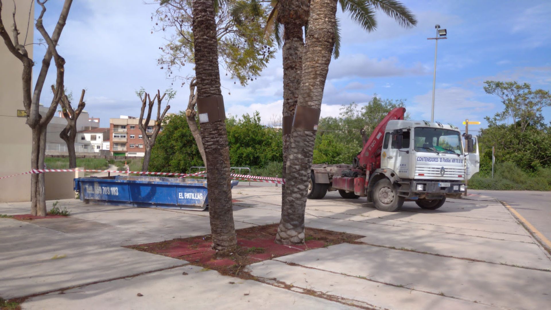 Un camión está estacionado en un estacionamiento al lado de palmeras.