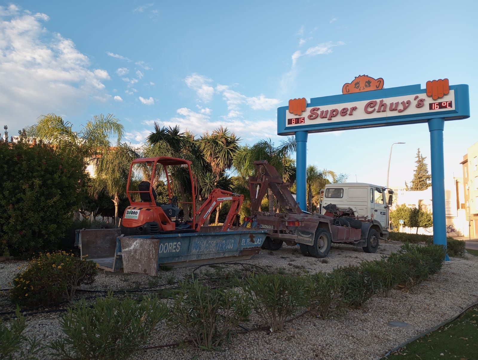 Un camión está estacionado debajo de un cartel que dice super chuy's