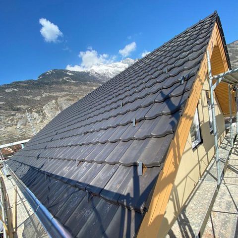 Jonction de toiture avec bardeaux, cheminée en briques et revêtement extérieur d'une maison