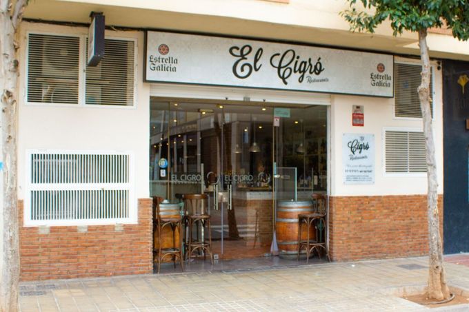 Fachada de la cafetería El Cafito, con la entrada abierta y mesas al aire libre