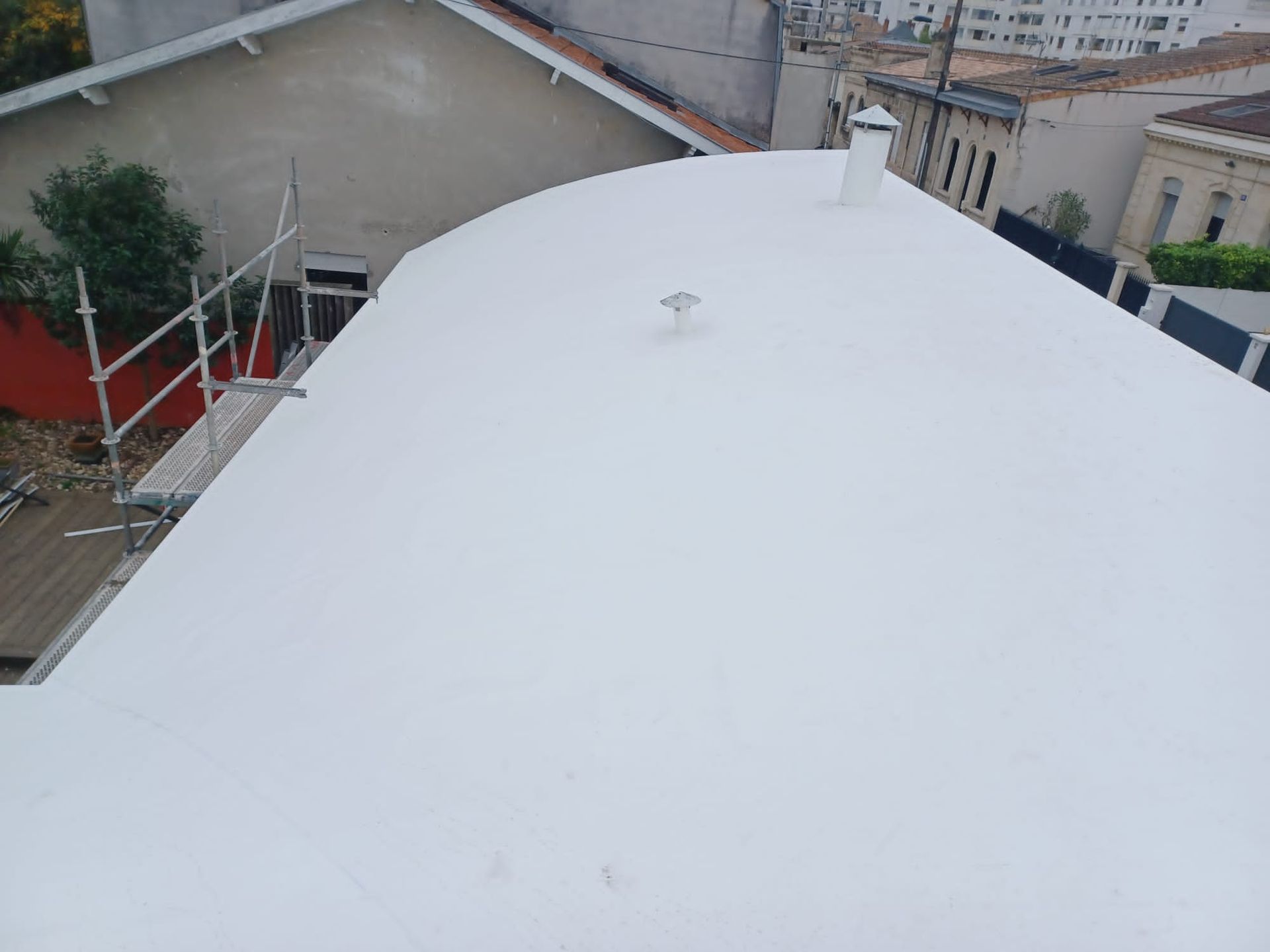 Un rouleau à peinture recouvert d'un revêtement gris texturé applique un enduit d'étanchéité.