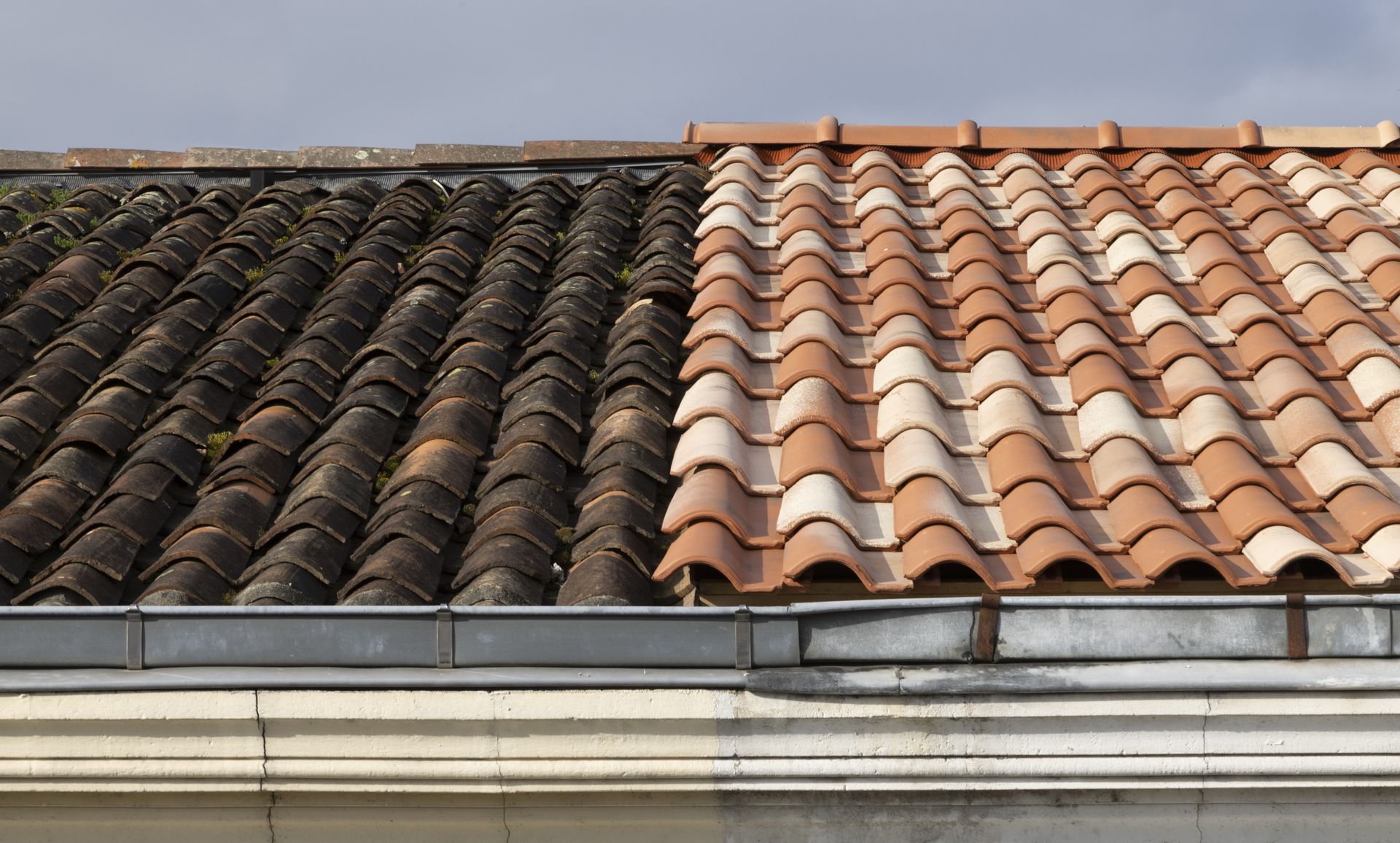 Comparaison côte à côte d'un toit de tuiles sombres et abîmé par les intempéries et d'une section de tuiles orange.