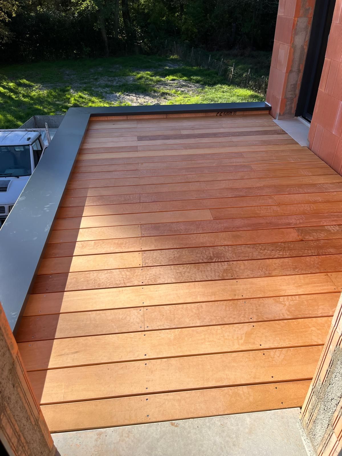 Vue panoramique depuis un toit recouvert d'une membrane noire plate, avec des bâtiments.