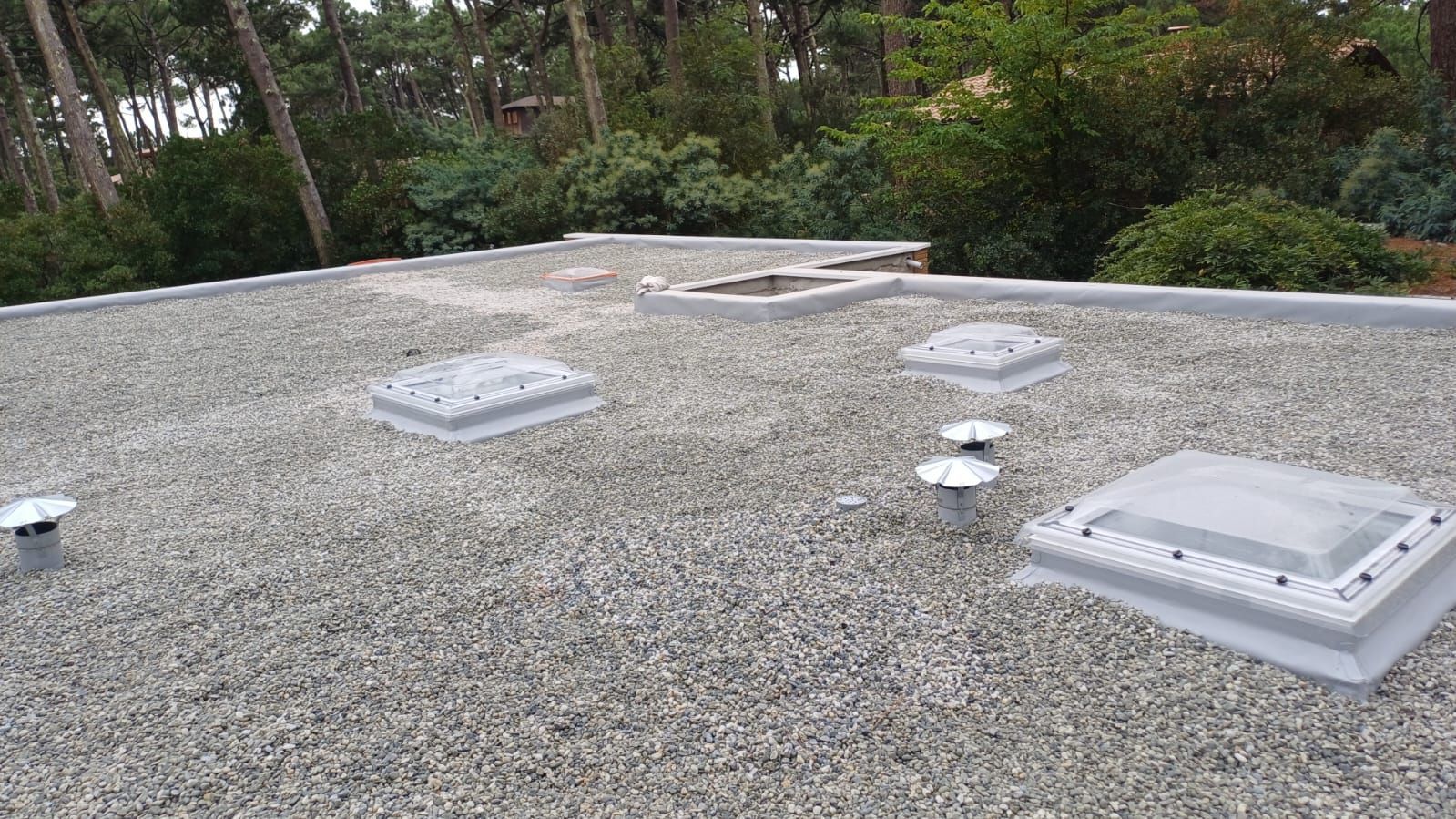 Un toit plat avec des graviers.