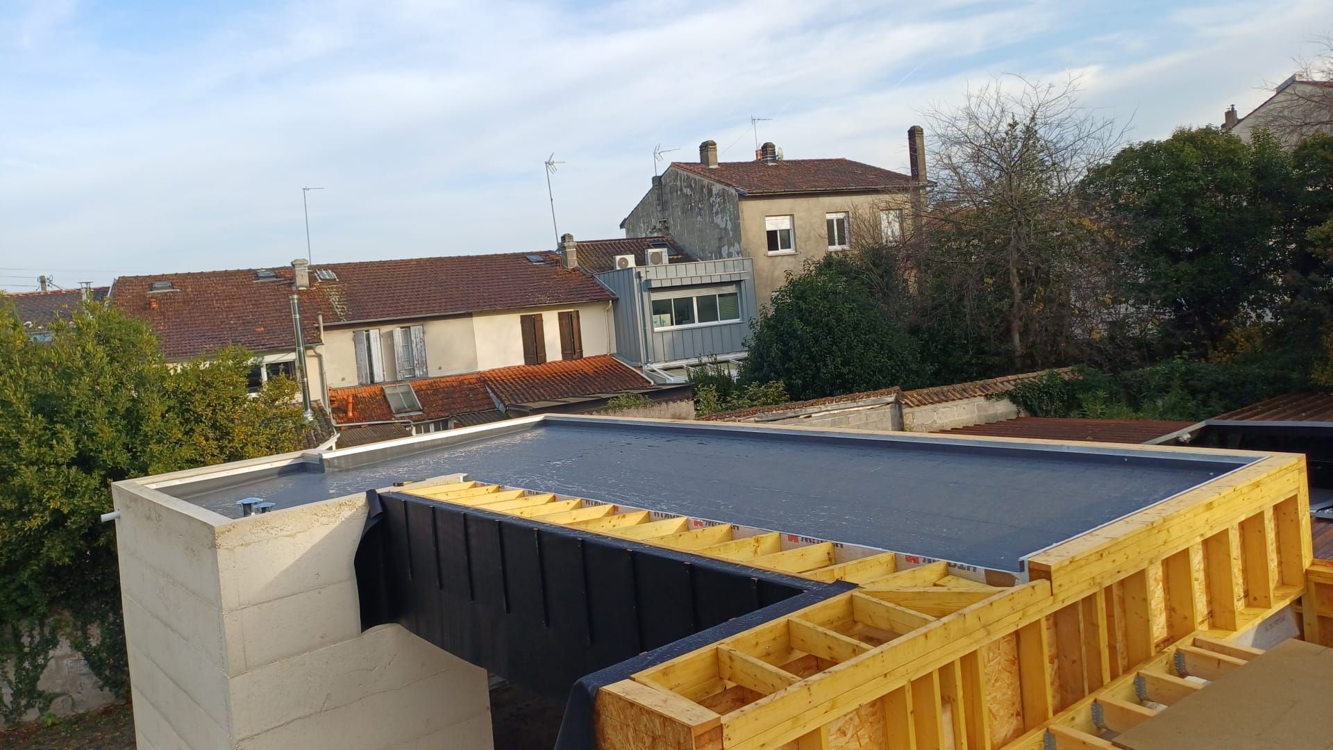 Vue depuis un toit recouvert d'un matériau lisse et sombre.