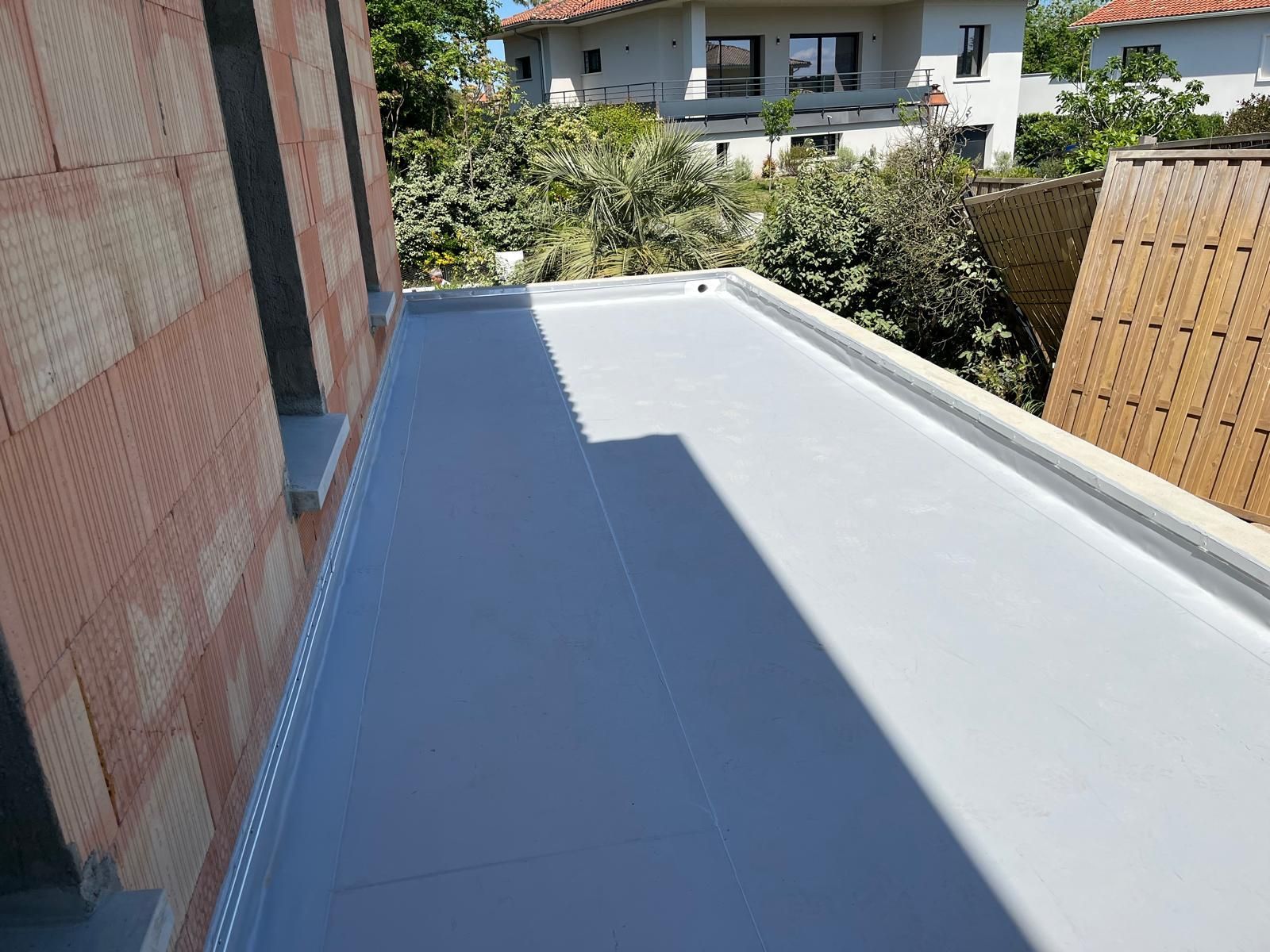 Mastic liquide clair sur une surface de toit.