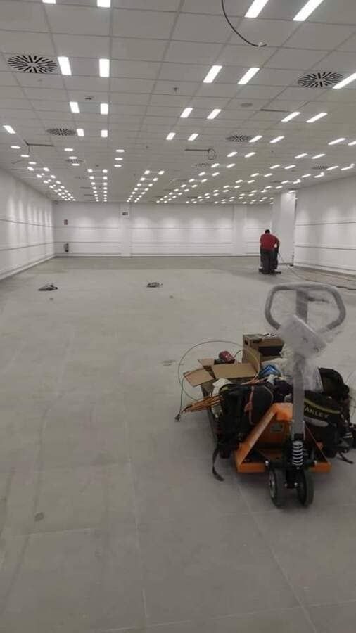 Una gran habitación vacía con una transpaleta en el medio.