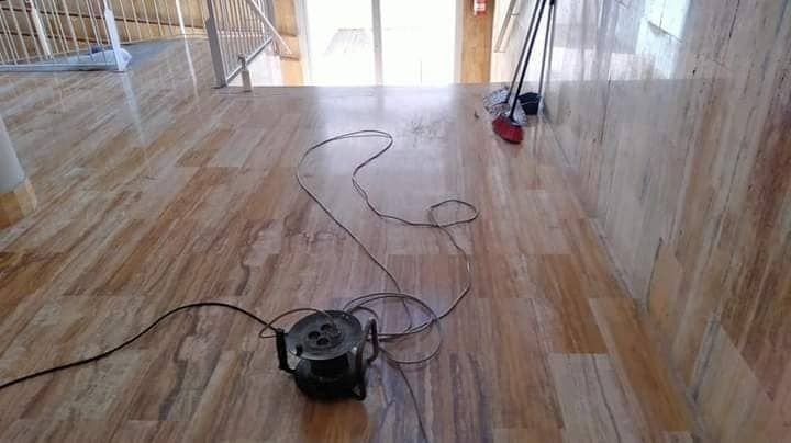 Una aspiradora está colocada sobre un piso de madera en una habitación.