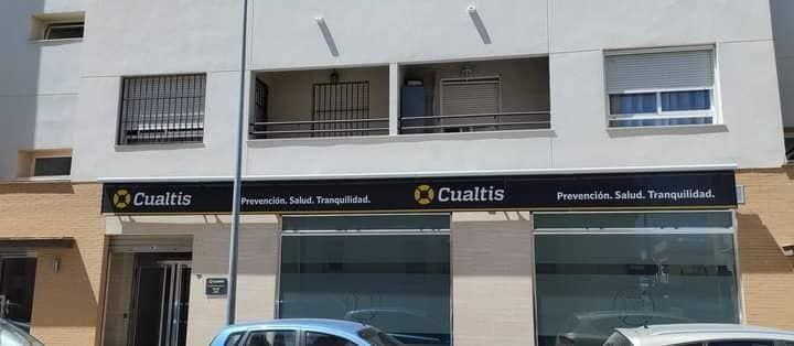 Un carro está estacionado frente a un edificio que dice cuautia